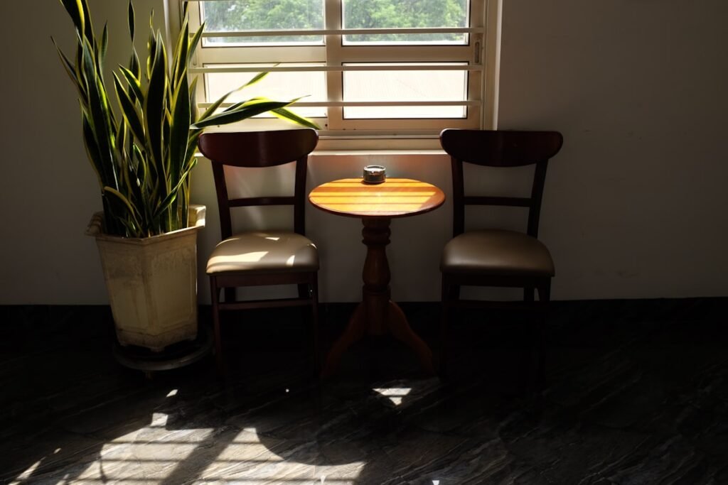 Twee stoelen met een tafeltje bij het raam